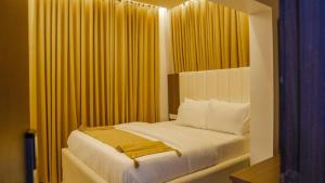 莱基LA FIFTHIN VILLA的一间卧室配有黄色窗帘的床