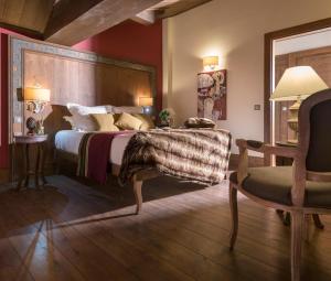 葱仁谷勒哈蒙杜卡什米尔酒店的一间卧室配有一张大床和一把椅子