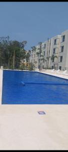 图卢姆Departamento en tulum Quintana roo的大楼前方的大型蓝色游泳池