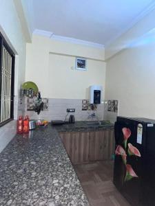瓦拉纳西Kashi Anadam HomeStay的一间带柜台和冰箱的厨房