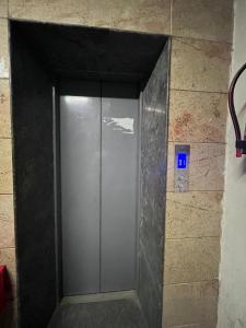 瓦拉纳西Kashi Anadam HomeStay的砖墙中的金属电梯门