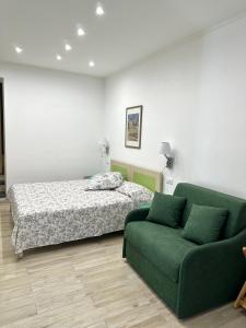 阿纳卡普里Hedera Capri B&B的一间卧室配有一张床和一张绿色沙发