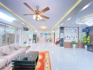岑山Mai Linh Villa - FLC Sam Son的带沙发和吊扇的客厅