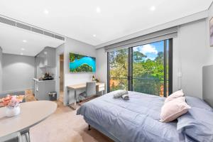 悉尼Nice and quite studio Roseville的一间卧室配有一张床、一张书桌和一个窗户。