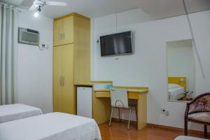 圣保罗山加布瑞欧酒店的客房设有两张床、一张桌子和一台电视机。