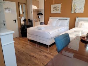 美因河畔法兰克福弗兰肯河畔旅馆的酒店客房设有两张床、一张桌子和一张桌子。