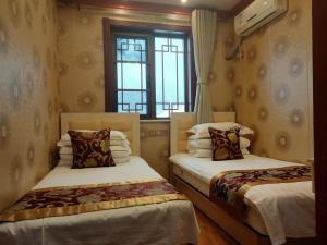 蓟州区天津市黄崖关长城家园酒店的带窗户的客房内的两张床