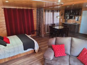 萨克雷克尔萨格奈5星家庭休闲度假村的一间卧室配有一张床、一张沙发和一张桌子