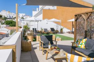 阿尔布费拉Golden Stay - B&B Experience的屋顶庭院配有椅子和遮阳伞。