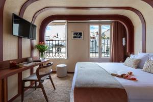 巴黎萨夏酒店的酒店客房配有一张床和一张书桌及一台电视