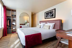 巴黎萨夏酒店的一间卧室配有一张大床、一张桌子和一张书桌