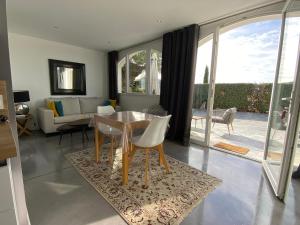 拉隆德莱丝莫里斯Appartement privé à la Villa Paradis de Valcros的客厅配有桌椅和沙发