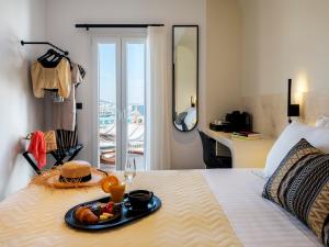 米克诺斯城Yalos Hotel Sunset view Mykonos town private rooms的一间酒店客房,床上放着一盘食物
