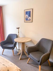 圣彼得奥尔丁Hotel Garni Silvana的房间里的两张椅子和一张桌子
