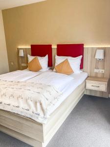 圣彼得奥尔丁Hotel Garni Silvana的一张白色大床,配有红色床头板和枕头