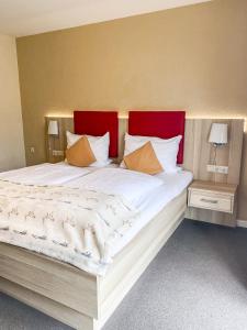 圣彼得奥尔丁Hotel Garni Silvana的一间卧室配有一张大床和红色床头板