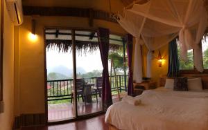 Hương Bá ThướcPù Luông Happy Home的一间卧室设有一张床,享有阳台的景色