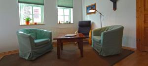 阿恩施塔特Ferienwohnung Wenzlaff的一间设有两把椅子、一张桌子和一盏灯的房间