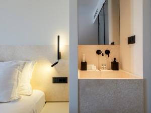 米克诺斯城Yalos Hotel Sunset view Mykonos town private rooms的一间卧室配有一张床和一个带镜子的水槽