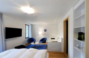 伦克斯特恩酒店的一间卧室配有2把蓝色椅子和1张床及书桌