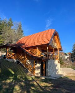 Sekulić Brvnara Tarska Zora的一座大型木制建筑,拥有橙色屋顶