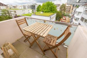 巴塞尔Special MODERN LiSA Apartment Basel, Bahnhof Grossbasel 10-STAR的阳台上配有一张木桌和两把椅子