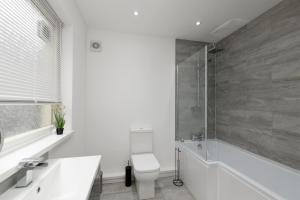 Modern House near Washeries Park的带淋浴、卫生间和盥洗盆的浴室