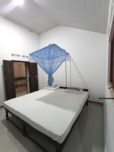 蒂瑟默哈拉默Bundala Resort的床上有蓝色的伞
