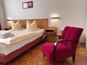 布拉格卡耐特膳食公寓的酒店客房,配有一张床和一张红色椅子