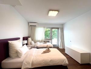 杜塞尔多夫Villa Düsseldorf的一间白色卧室,配有两张床和窗户
