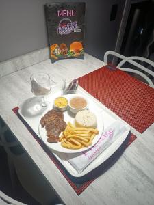 圣保罗Prestige Motel 3的一小盘肉和薯条以及一杯葡萄酒