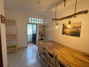 拉波塞拉Happy Hostel Sagres的一间带木桌和椅子的用餐室