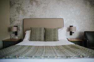 沃里克环球酒店的一间卧室配有一张带2个床头柜和2盏灯的床。