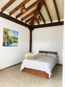 里奥内格罗Hostal Inn II Rionegro的一间带一张床的卧室,位于带木制天花板的房间内