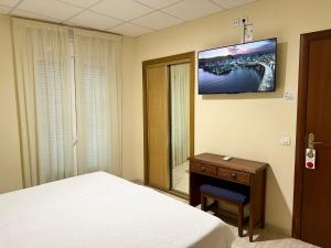 霍斯皮塔勒·德尔英福桑丘酒店的一间卧室配有一张床、一张桌子和一面镜子