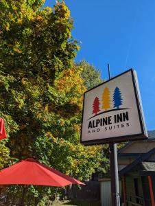 尼尔逊Alpine Inn & Suites的飞机旅馆和套房的标志,旁边是伞
