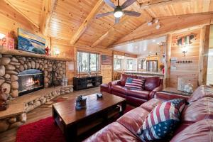 大熊湖Catalina Creekside Cabin - Log home with wood burning fireplace for an immersive mountain getaway!的带沙发和壁炉的客厅
