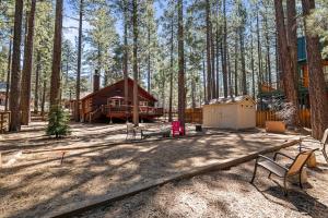 大熊湖Catalina Creekside Cabin - Log home with wood burning fireplace for an immersive mountain getaway!的树林中的小屋,配有野餐桌和长凳