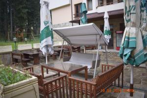 波罗维茨Villa Park Guest Apartments的桌椅、遮阳伞和桌子