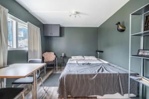 雷克雅未克Charming cottage in downtown Reykjavik - Birta Rentals的卧室配有一张床和一张桌子及椅子