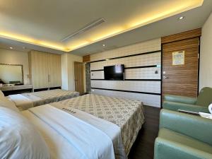 台中市爱莱时尚旅馆的酒店客房设有两张床和电视。