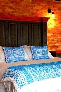 TlatlauquitepecHotel Casa Xaa的一张带蓝色和白色枕头的床