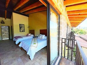 TlatlauquitepecHotel Casa Xaa的带阳台的客房内的两张床