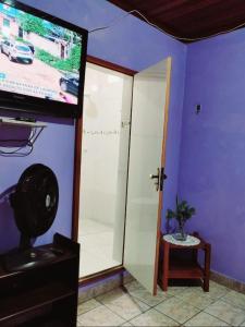 帕林廷斯7 camas de casal - Casa próxima ao Bumbódromo的一间配有电视和滑动玻璃门的客房