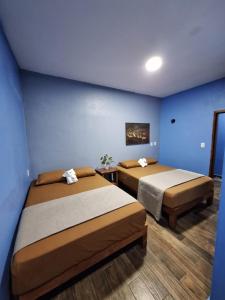 Barrio NuevoLA CASA AZUL DE SAMARA的蓝色墙壁客房的两张床