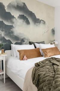 什切青TS Hello City Apartment的卧室配有带云雾壁画的大型白色床。