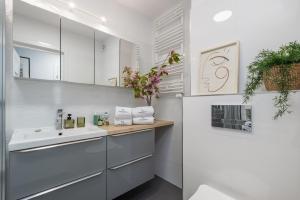 什切青TS Hello City Apartment的白色的浴室设有水槽和镜子