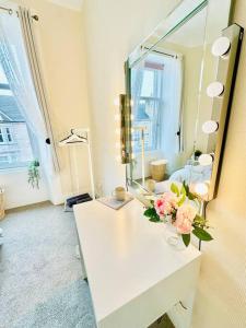 邓巴顿Dumbarton cosy home, Loch Lomond的浴室设有镜子和花瓶,位于柜台上