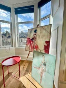 邓巴顿Dumbarton cosy home, Loch Lomond的一间拥有两幅画作的房间,一张椅子和一张桌子