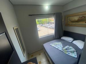 阿帕雷西达Maranata Hotel的一间小卧室,配有床和窗户